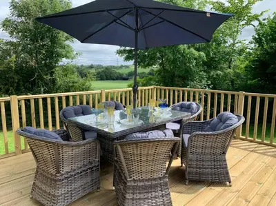 a table and chairs with an umbrella on a deck at WestLaigh Lrg Luxury Country Farm House 20 min from the city in Glassford