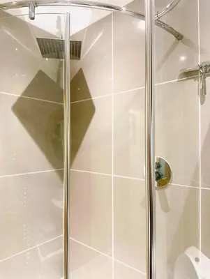 a shower with a glass door in a bathroom at Gleddoch Coach House in Langbank