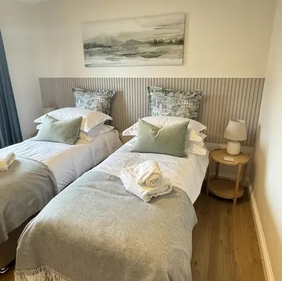 two beds sitting next to each other in a bedroom at Island View - Spacious Two Bedroom Oban Apartment with Sea Views in Oban