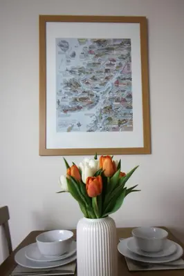 a vase with orange and white flowers on a table at Island View - Spacious Two Bedroom Oban Apartment with Sea Views in Oban