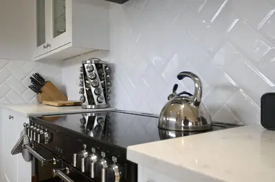 a kitchen with a stove with a tea kettle on it at Avoca Lodge in Fort William