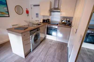 a kitchen with a washer and dryer in it at Ardbeg Apartment in Oban
