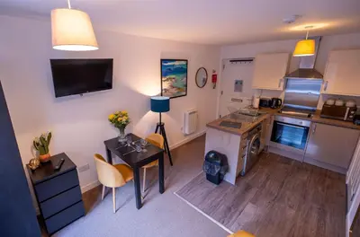 a small kitchen with a table and a counter top at Ardbeg Apartment in Oban