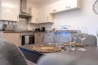 a kitchen with a table with wine glasses on it at Bowmore Apartment in Oban