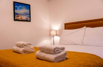 a bedroom with a bed with two folded towels at Bowmore Apartment in Oban