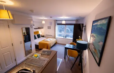 a hotel room with a bedroom with a bed and a mirror at Jura Apartment in Oban