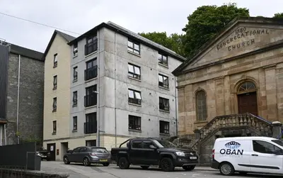 a white van parked in front of a building at Jura Apartment in Oban