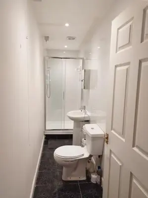 a white bathroom with a toilet and a shower at M Rooms 97a at the Brandy Bar in Kirk of Shotts
