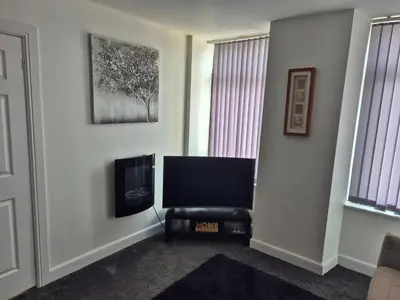 a living room with a flat screen tv on a wall at M Rooms 97a at the Brandy Bar in Kirk of Shotts