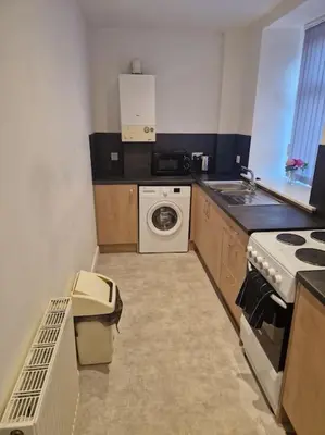 a small kitchen with a stove and a washing machine at M Rooms 97a at the Brandy Bar in Kirk of Shotts