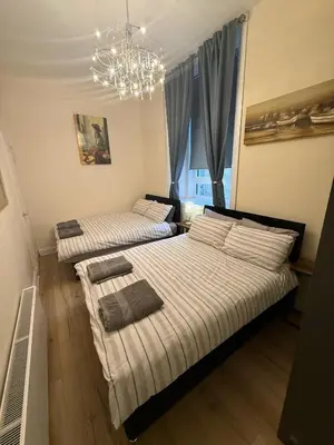 two beds in a bedroom with a chandelier at One Bedroom Flat in Central Edinburgh Old Town , Heart of Edinburgh Flat Sleeps 4 in Edinburgh