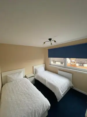 two beds in a room with a window at Gateway to the Loch in Balloch