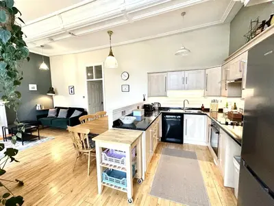an open kitchen and living room with a couch at 1 The Cairn Kilmartin - Beautiful Victorian Flat, Pet Friendly in Kilmartin