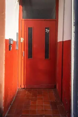 a red door in a hallway with a tile floor at Helensburgh Holiday Apartment in Helensburgh