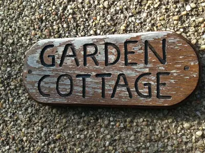 a sign that says garden cottage on the side of a building at Garden Cottage Helensburgh in Helensburgh