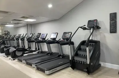 a gym with a row of tread machines in a room at Apex Dunblane Hydro in Dunblane