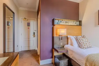 a small bedroom with a bed and a table at Apex Dunblane Hydro in Dunblane