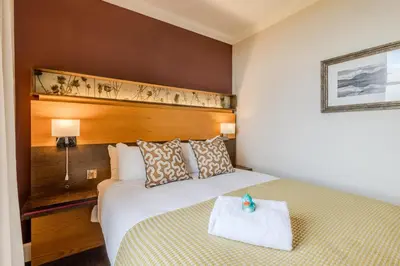 a bedroom with a bed with a wooden headboard at Apex Dunblane Hydro in Dunblane