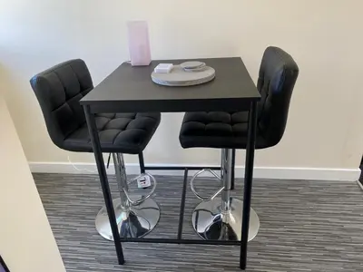 a table with two black chairs and a black table at WHITEHILL STABLES in Kirknewton