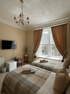 a bedroom with two beds and a window at Acorn House Callander in Callander