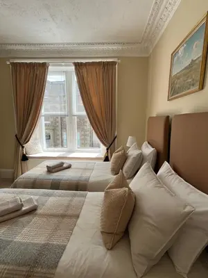 a bedroom with two beds and a window at Acorn House Callander in Callander