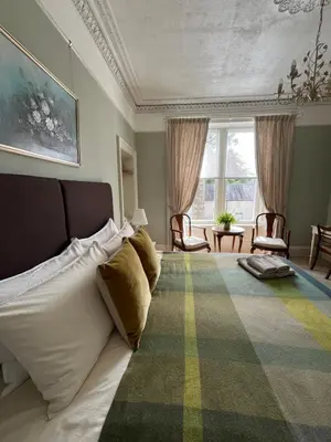 a bedroom with a bed and a large window at Acorn House Callander in Callander