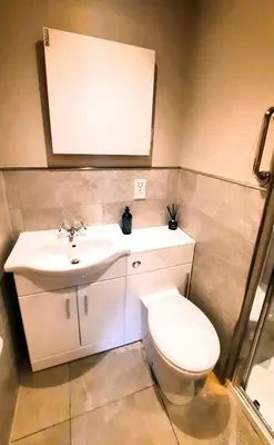 a bathroom with a white toilet and a sink at Clarinnes Cottage in Luss