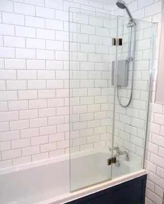a bathroom with a shower with white subway tiles at Clarinnes Cottage in Luss