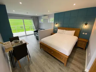 a bedroom with a bed and a table and a room at Laigh Letterpin Lodge in Girvan