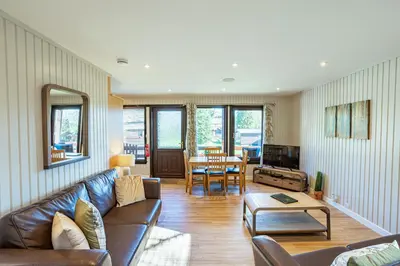 a living room with a couch and a table at Birch Lodge in Newton Stewart