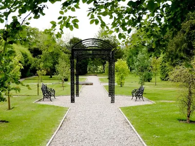 a walkway in a park with two metal sculptures at Macdonald Houstoun House in Livingston