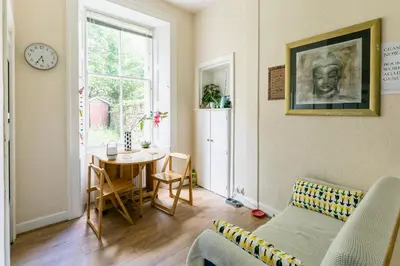 a living room with a couch and a table at Palm Tree Apartment- Period Home with Cat in Edinburgh