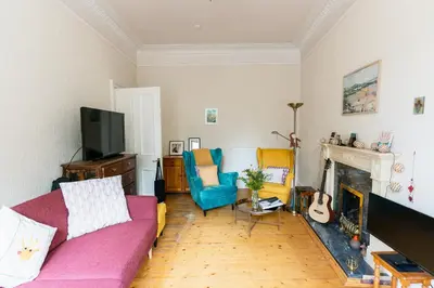 a living room with a couch and a fireplace at Palm Tree Apartment- Period Home with Cat in Edinburgh