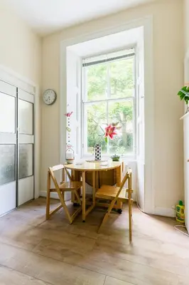 a dining room with a table and a window at Palm Tree Apartment- Period Home with Cat in Edinburgh