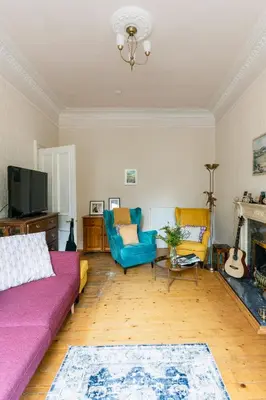 a living room with a purple couch and yellow chairs at Palm Tree Apartment- Period Home with Cat in Edinburgh
