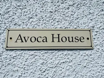 a sign for aaza house on the side of a building at Avoca House in Fort William