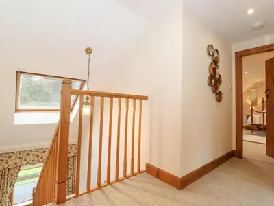 a staircase in a home with wooden railings at Glen View in Dumfries