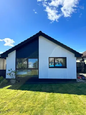 a white house with large windows on a yard at Sleeps7-Parking-Garden-Patio in Johnstone
