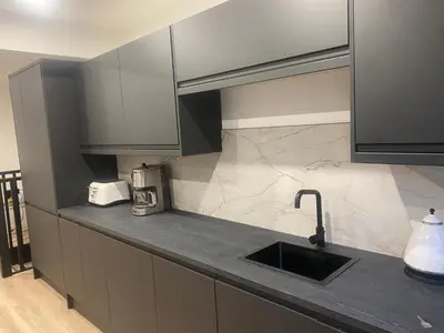 a kitchen with a sink and a counter top at Sleeps7-Parking-Garden-Patio in Johnstone