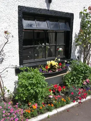 a window with a bunch of flowers in a window box at Lion and Unicorn Hotel in Thornhill