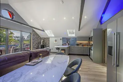 a kitchen and living room with a table and chairs at Dundonald Landing Palms 1 in Oban