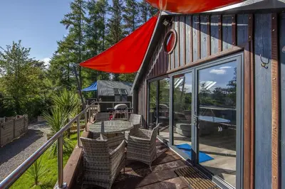 a house with a patio with a table and chairs at Dundonald Landing Palms 1 in Oban