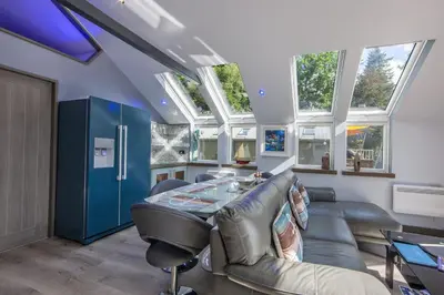 a living room with a table and some windows at Dundonald Landing Palms 1 in Oban