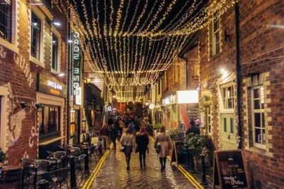 a group of people walking down a street with christmas lights at Rustic Top Floor West End Pad With Balcony, Parking next to Byers Road, Aston Lane, Glasgow Uni in Glasgow