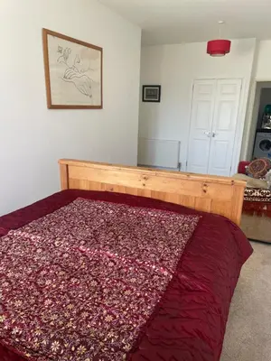 a bedroom with a bed with a red blanket on it at Homestay in Glasgow