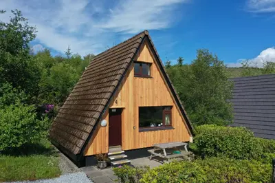 a tiny house with a brown roof at 1 Bedroom Cabin with Mountain & Loch Views - Quiet Location between Glencoe & Ben Nevis in Corran