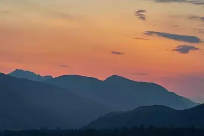 a sunset with mountains in the background at 1 Bedroom Cabin with Mountain & Loch Views - Quiet Location between Glencoe & Ben Nevis in Corran