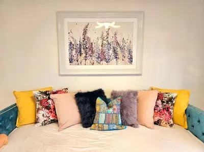 a couch with pillows and a picture on the wall at 3 Bed House with 6 Beds by Sensational Stay in Edinburgh