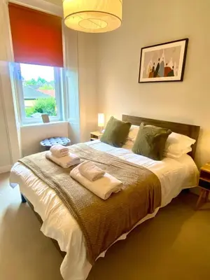 a bedroom with a large bed with towels on it at Ochil View in Stirling