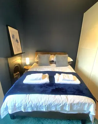 a bedroom with a large bed with two pillows at Ochil View in Stirling
